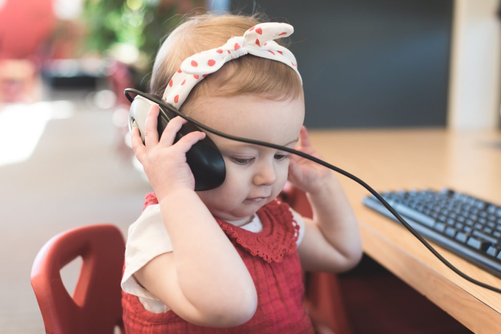 Petite fille au téléphone avec une souris d'ordinateur.